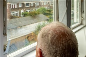 Oudere man met grijs haar kijkt naar beneden